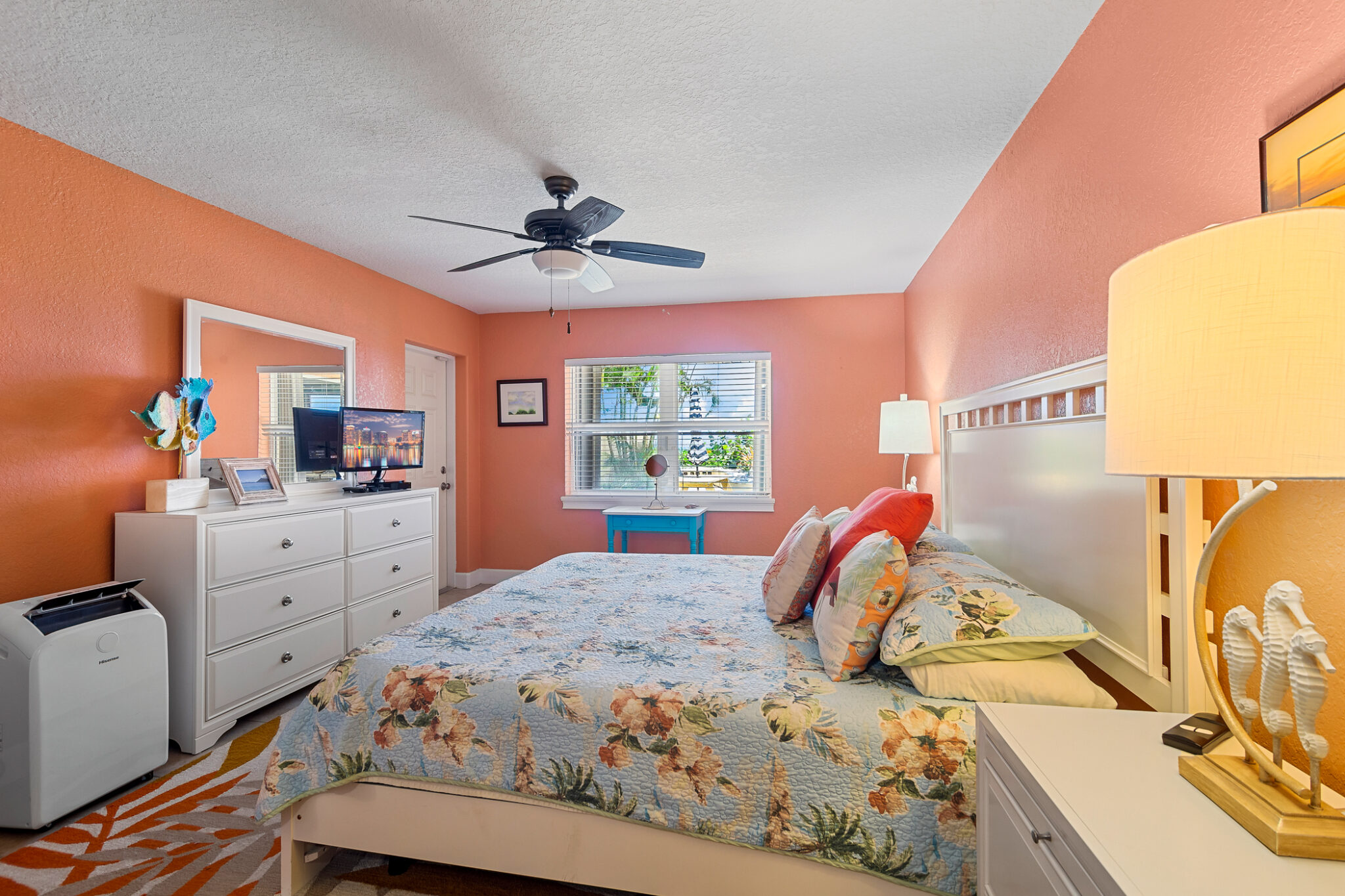 Bright welcoming looking room with orange paint and white furniture