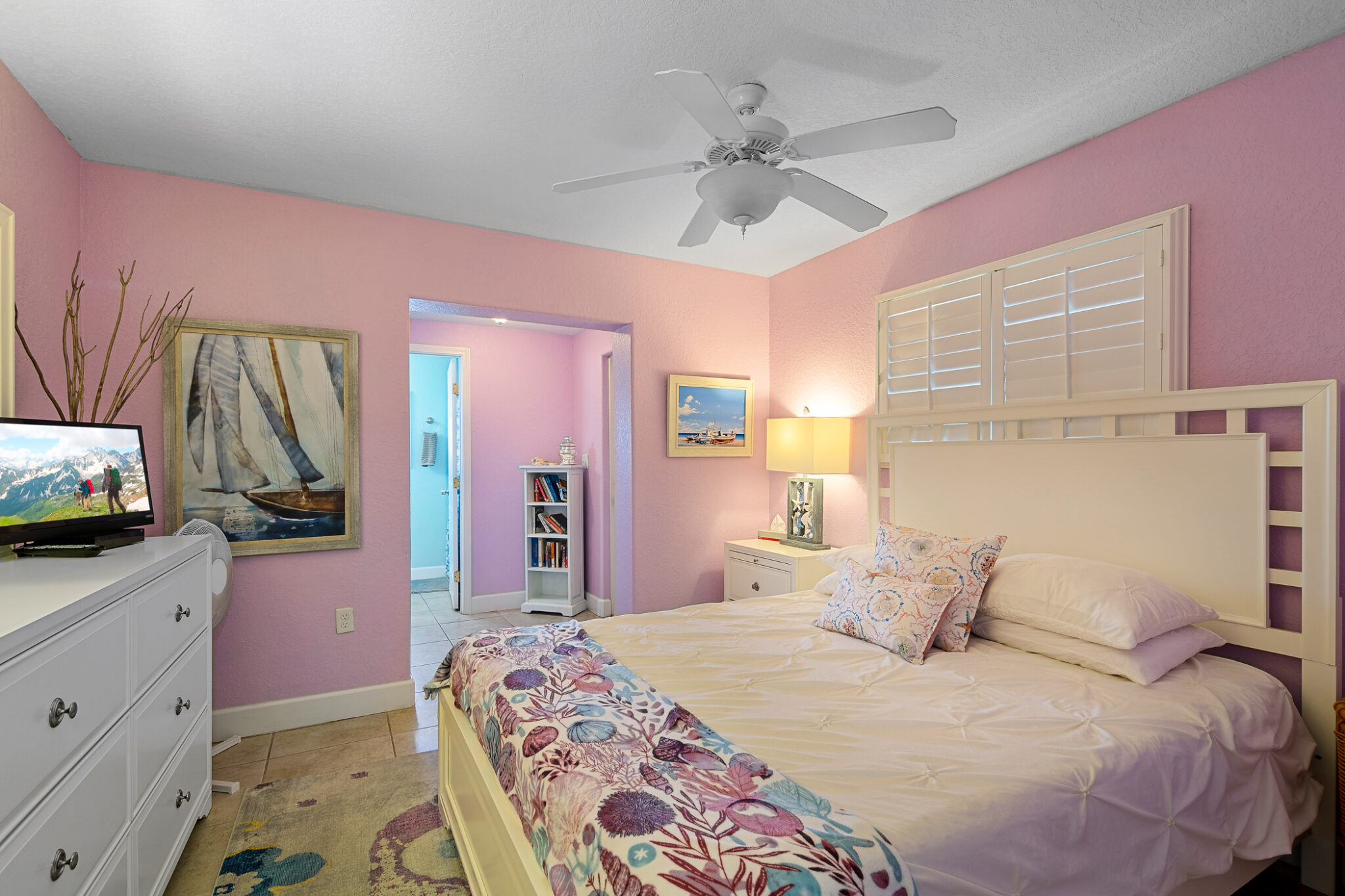 Large colorful master suite with white furniture and light pink walls