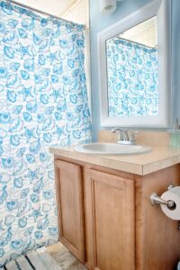 Interior view of bathroom sink with a blue and white starfish shower curtain.