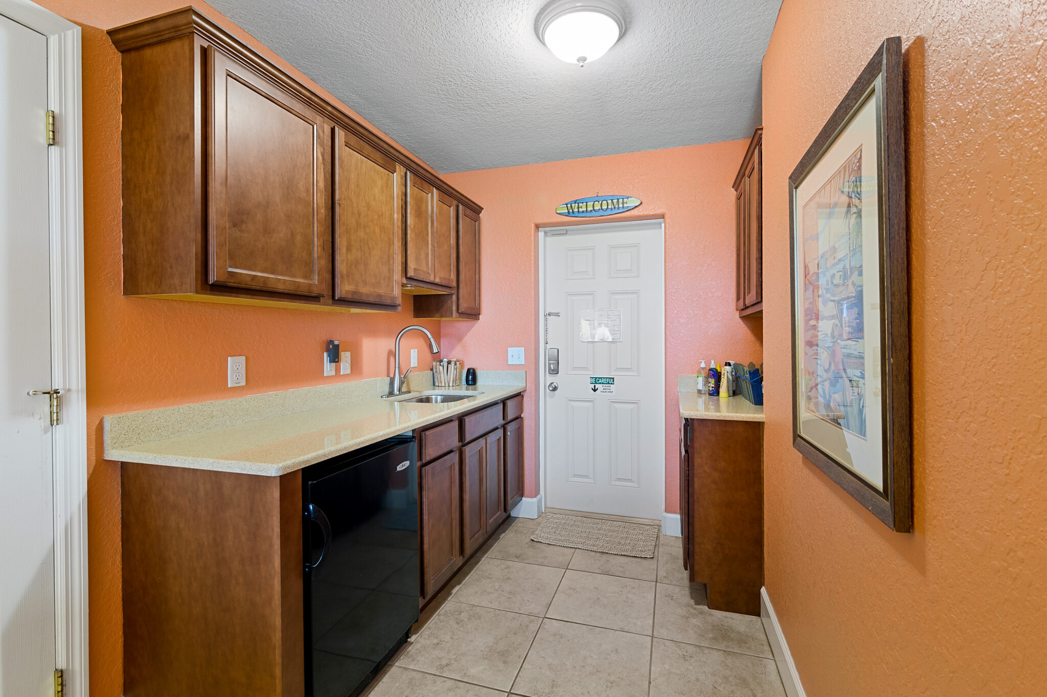 Kitchen area with light orange paint and gold marble countertops