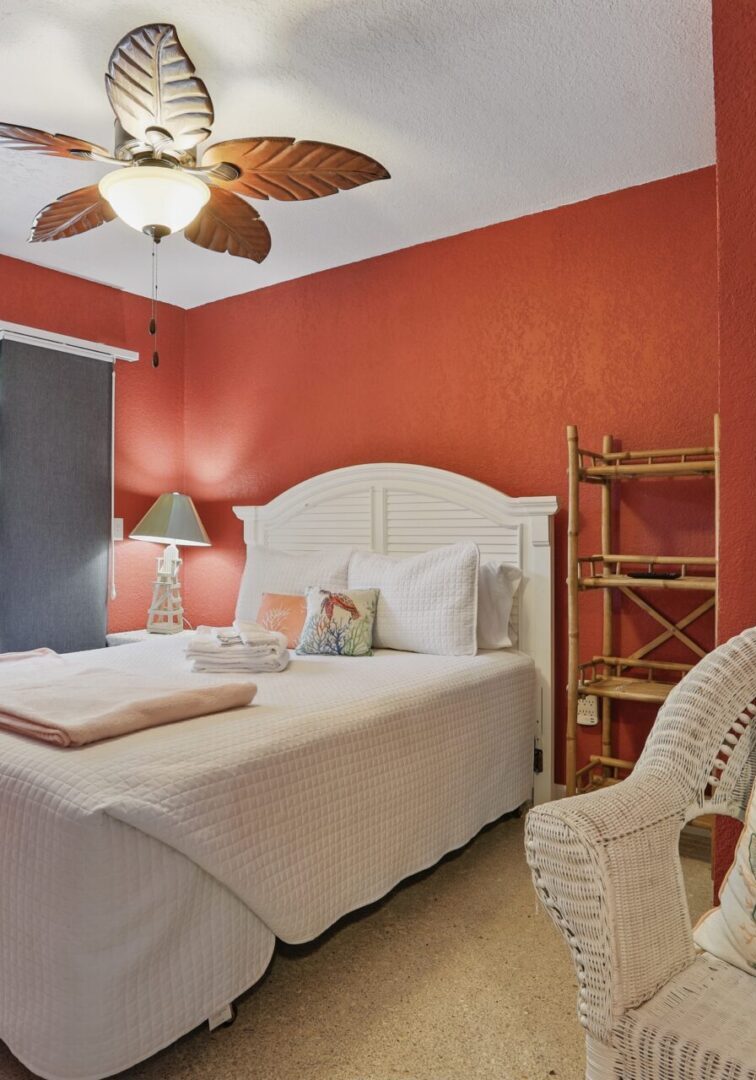 Cozy bedroom with warm terracotta walls and a white bed.